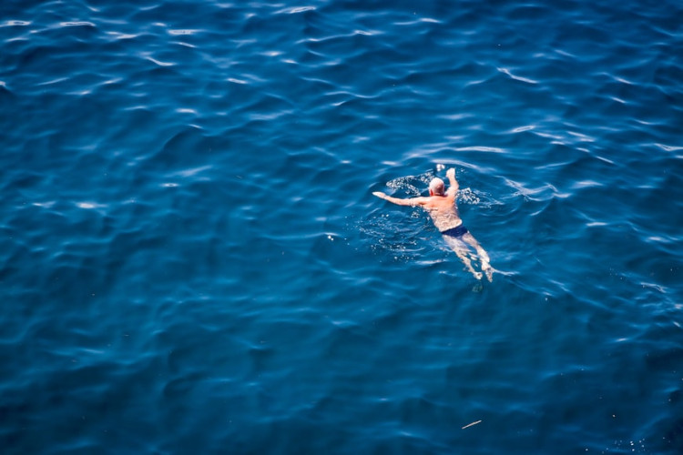 man swimming in speedos
